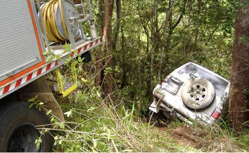 The 4WD was chained to a fire truck to prevent it from going down the embankment. The 4WD was chained to a fire truck to prevent it from going down the embankment.